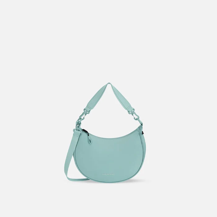 A Sherpani Mina Surf Blue Medium Crossbody Bag, front view showing strap options on white background.  #color_surf-blue