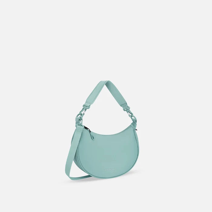 A Sherpani Mina Surf Blue Medium Crossbody Bag, 3/4 view showing strap options on white background.  #color_surf-blue