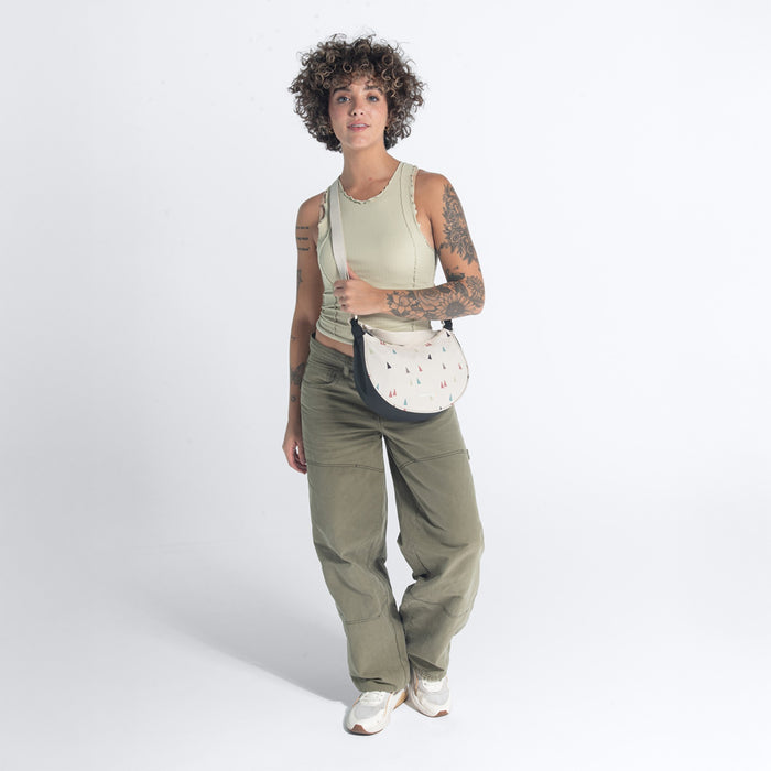 Woman wearing a Sherpani Mina Terrazzo Print Medium Crossbody Bag against white background.  #color_terrazzo-print