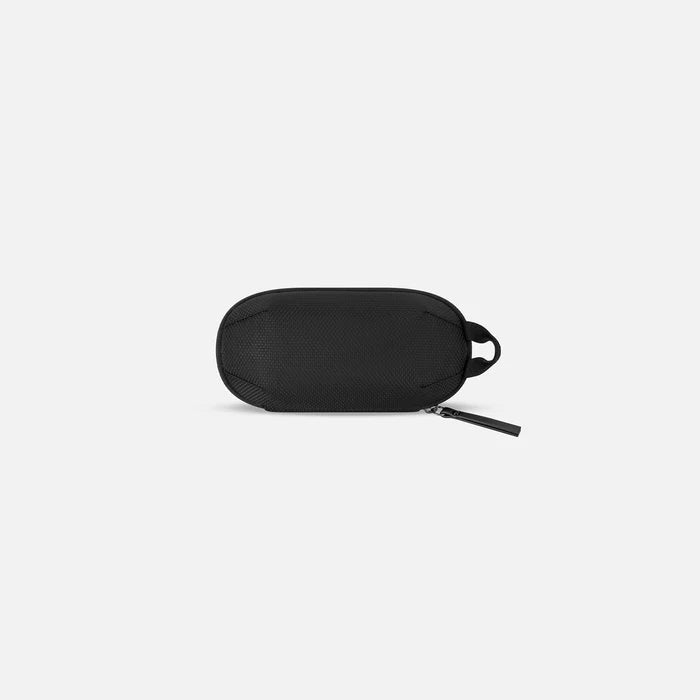 A Sherpani Co-Pilot Granite  Travel Toiletry Case, back view showing black backside against white background. #color_granite-grey
