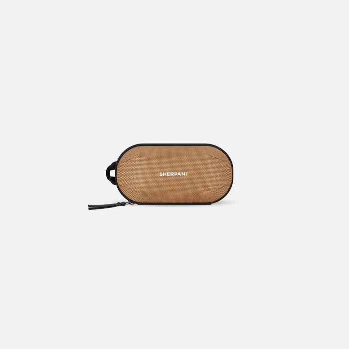 A Sherpani Mini Co-Pilot Sand Mini Travel Organizer, front view showing side handle and main zipper against white background. #color_sand-tan