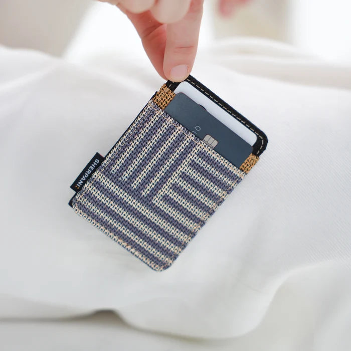 A woman holding a Sherpani Porter Passport Credit Card Sleeve Wallet against a white background.  #color_passport-print