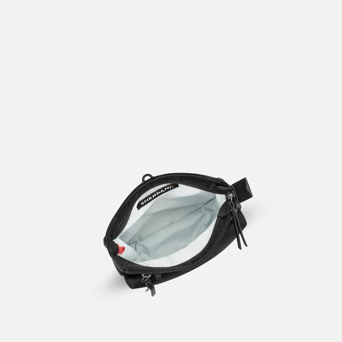 A Sherpani Prima Carbon Black Anti-theft Travel Crossbody, above view showing inside pocket on a white background. #color_carbon-black