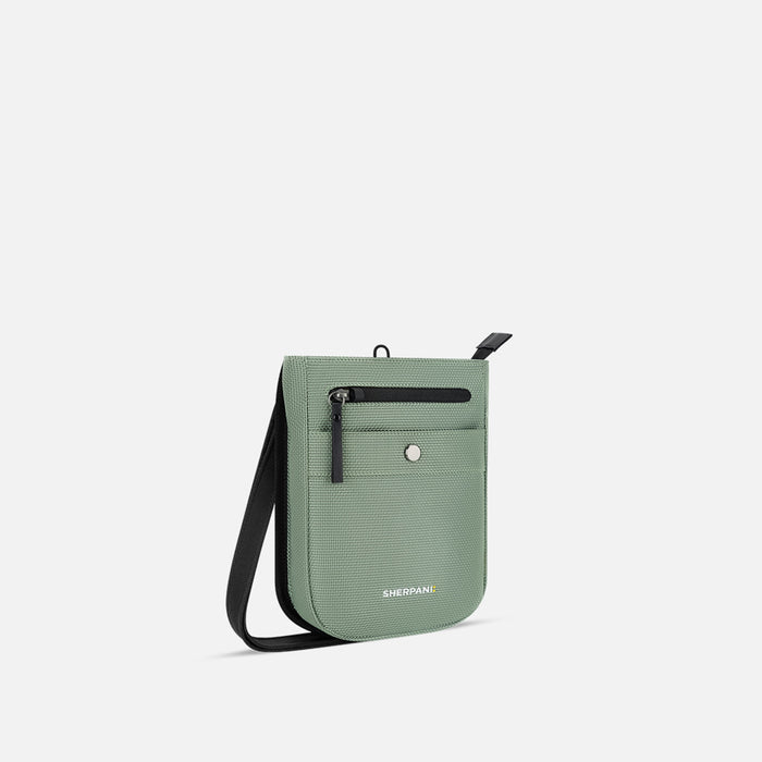 A Sherpani Prima Aloe Mist Green Anti-theft Travel Crossbody, 3/4 view showing lockable pocket and strap on white background. #color_aloe-mist-green
