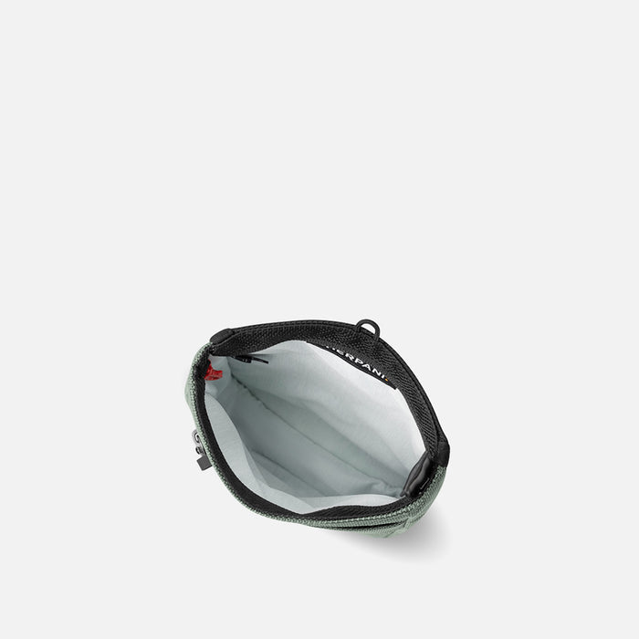 A Sherpani Prima Aloe Mist Green Anti-theft Travel Crossbody, above view showing inside pocket on a white background. #color_aloe-mist-green