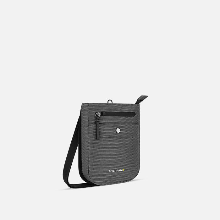 A Sherpani Prima Granite Anti-theft Travel Crossbody, 3/4 view showing lockable pocket and strap on white background. #color_granite-grey
