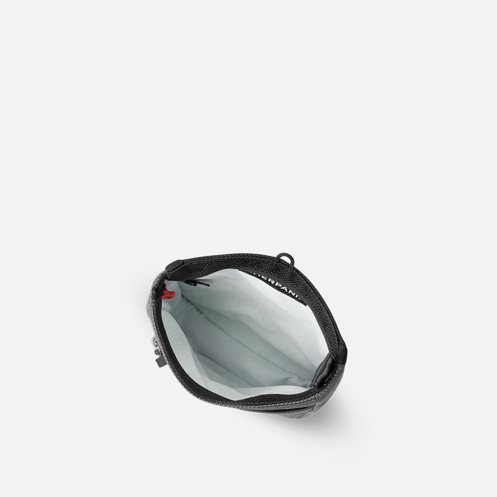 A Sherpani Prima Granite Anti-theft Travel Crossbody, above view showing inside pocket on a white background.  #color_granite-grey