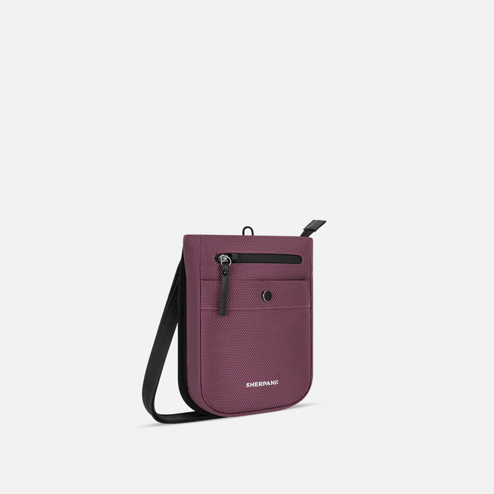 A Sherpani Prima Smoky Orchid Anti-theft Travel Crossbody, 3/4 view showing lockable pocket and strap on white background.  #color_smoky-orchid-pink