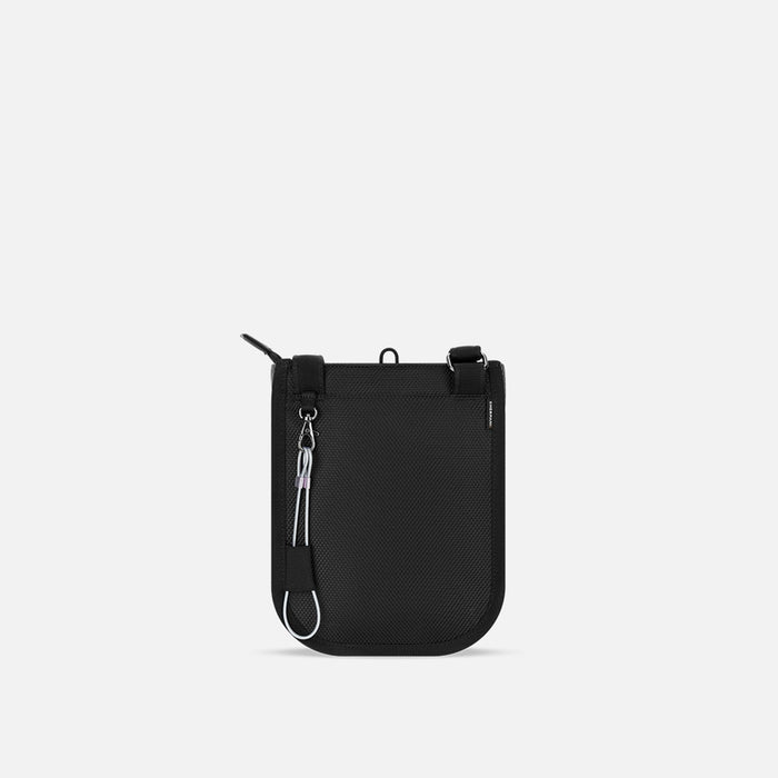 A Sherpani Prima Smoky Orchid Anti-theft Travel Crossbody, back view showing black backside & chair lock on white backdrop.  #color_smoky-orchid-pink