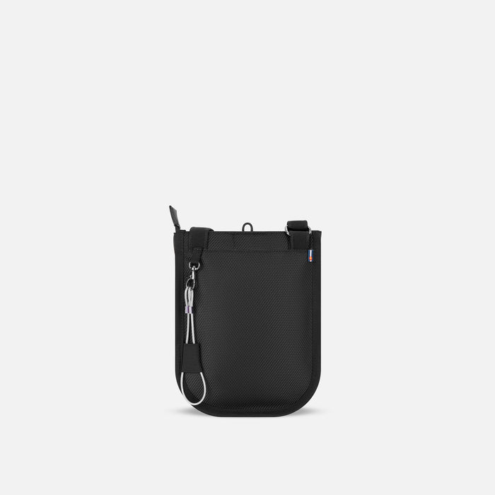 A Sherpani Prima Carbon Travel Crossbody, back view showing the strap & chair lock against white background. #color_granite