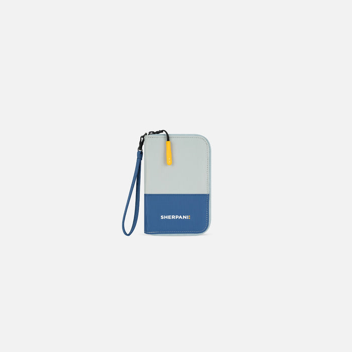 A Sherpani Rio Seastone Passport Wallet, front view showing wrist strap on white backdrop.  #color_seastone