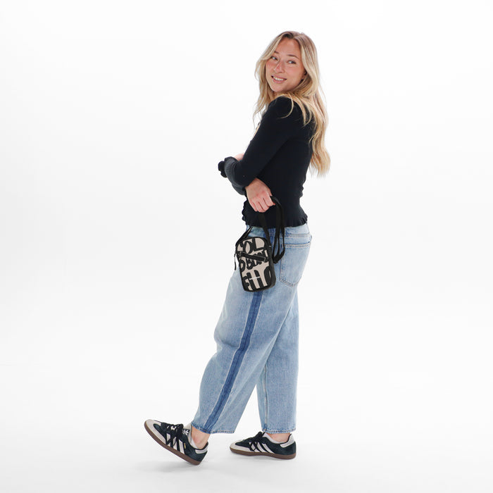Woman holding a Sherpani Rogue Ciao Mini Crossbody against white background.   #color_ciao-print