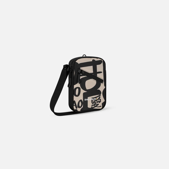 A Sherpani Rogue Ciao Mini Crossbody, 3/4 view showing lockable pocket & strap on white backdrop.  #color_ciao-print