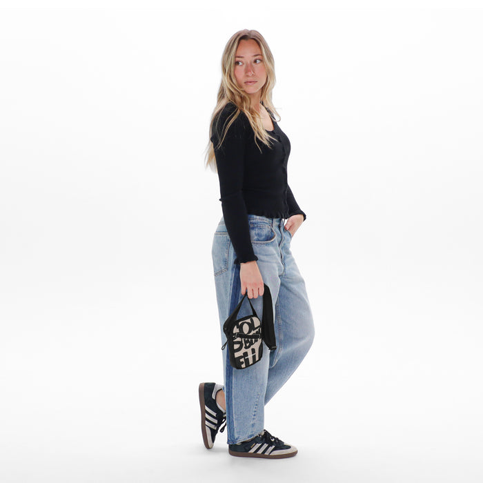 Woman holding a Sherpani Rogue Ciao Mini Crossbody against white background.   #color_ciao-print