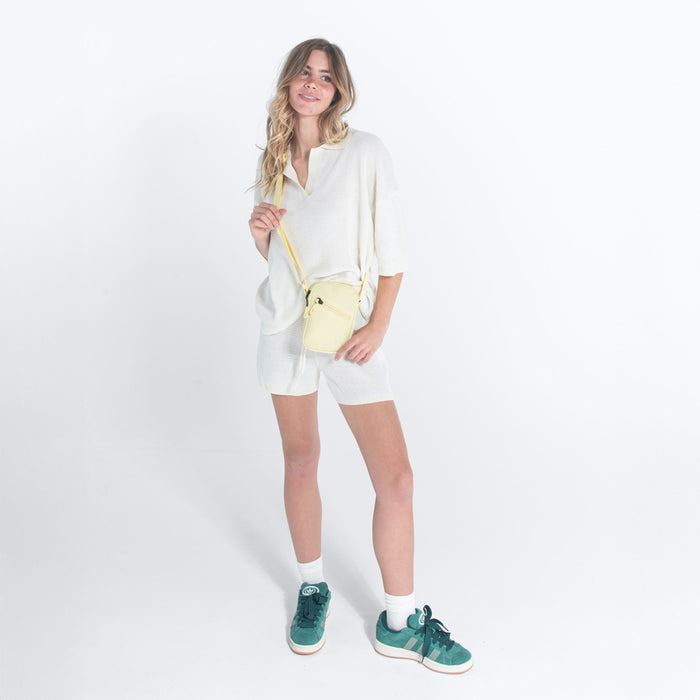 Woman wearing a Sherpani Rogue Sol Yellow Mini Crossbody against white background. #color_sol-yellow