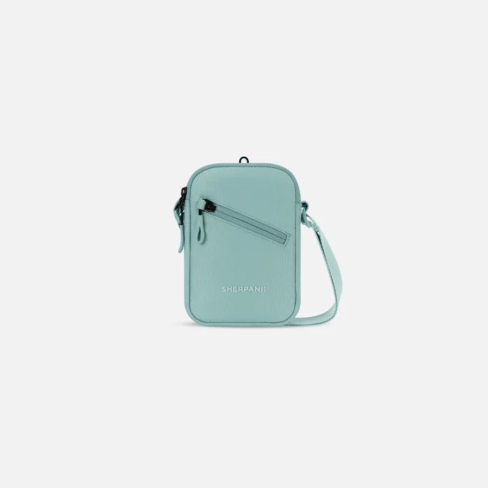 A Sherpani Rogue Surf Blue Mini Crossbody, front view showing lockable pocket & strap on white backdrop.  #color_surf-blue