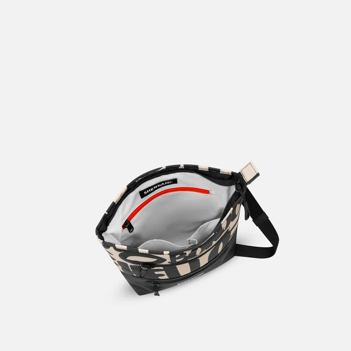A Sherpani Sadie Ciao Crossbody Bag, above view showing inside main pocket against white backdrop.    #color_ciao-print