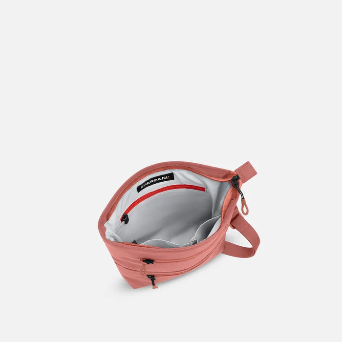 A Sherpani Sadie Desert Pink Crossbody Bag, above view showing inside main pocket against white backdrop.    #color_desert-pink
