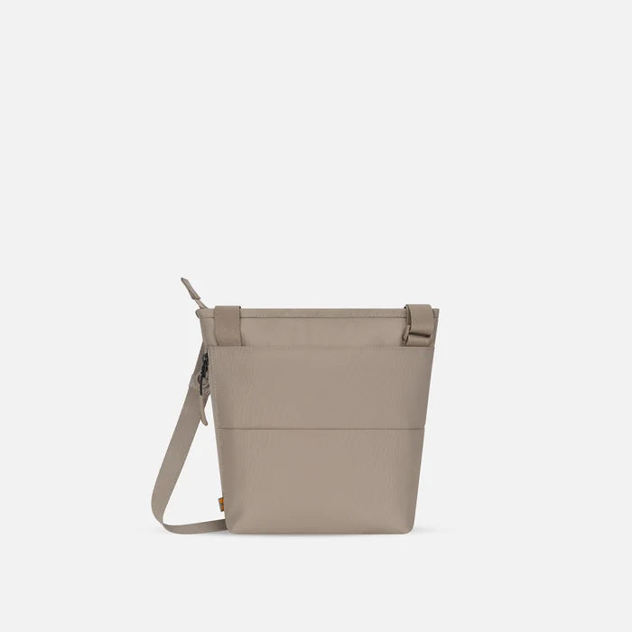 A Sherpani Sadie Dune Crossbody Bag, back view showing the side pocket.  #color_dune-tan