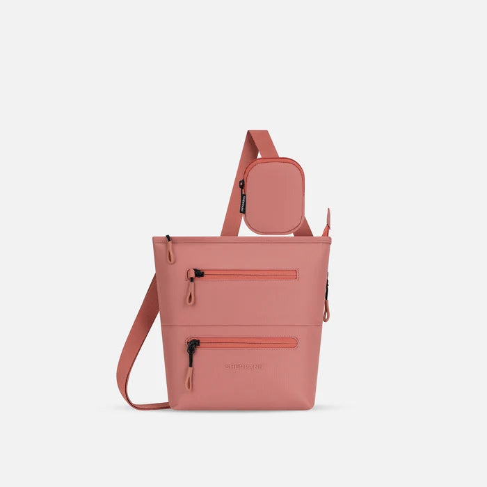 A Sherpani Sadie Desert Pink Crossbody Bag, front view showing pouch attached to strap and front lockable zipper pockets. #color_desert-pink