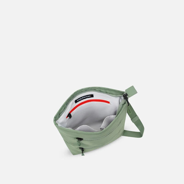 A Sherpani Sadie Olivine Crossbody Bag, above view showing inside main pocket against white backdrop.    #color_olivine-green