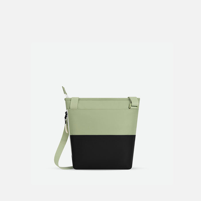 A Sherpani Sadie Palm Green Crossbody Bag, back view showing side pocket against white backdrop.  #color_palm-green