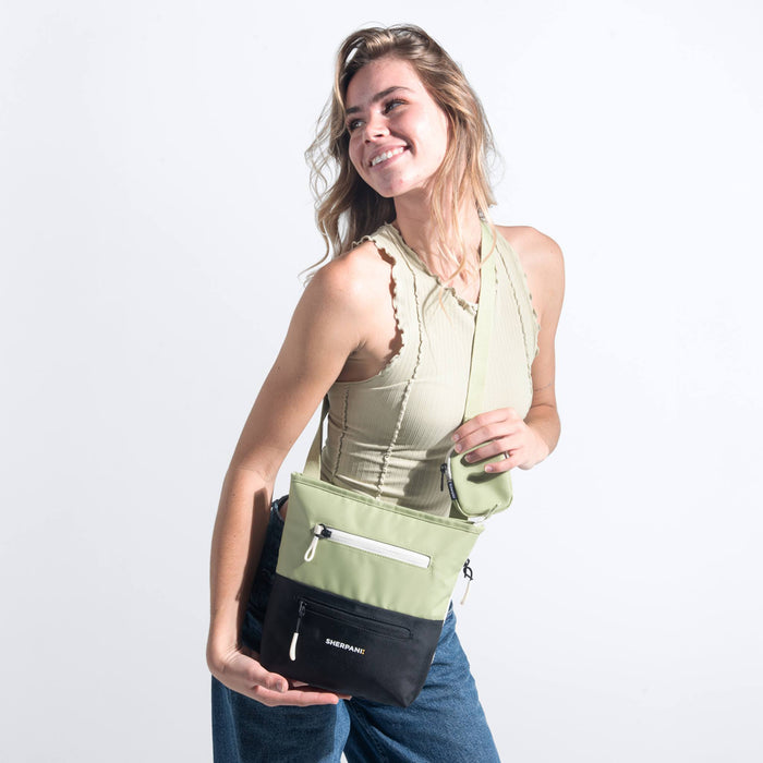 Woman wearing a Sherpani Sadie Palm Green Crossbody Bag against white backdrop. #color_palm-green