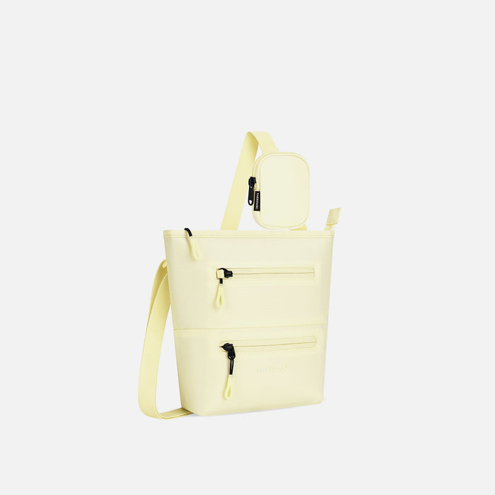 A Sherpani Sadie Sol Yellow Crossbody Bag, 3/4 view showing lockable Pocket & strap pouch against white backdrop.   #color_sol-yellow