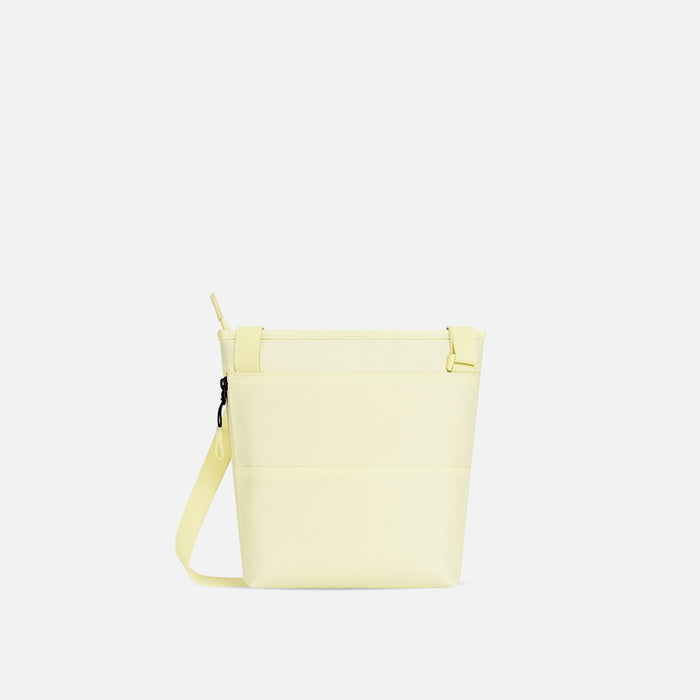 A Sherpani Sadie Sol Yellow Crossbody Bag, back view showing side pocket against white backdrop.  #color_sol-yellow