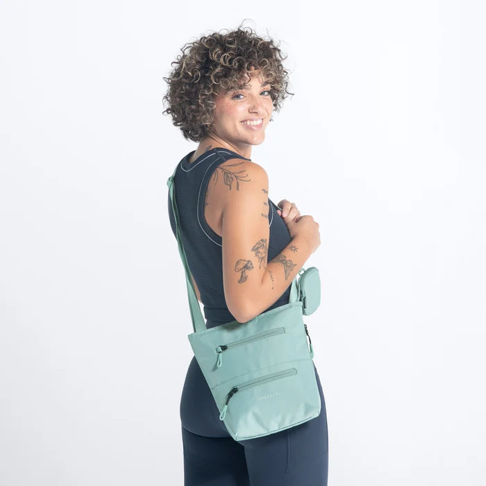 A woman wearing Sherpani Sadie Surf Blue Crossbody Bag against a white background. #color_surf-blue