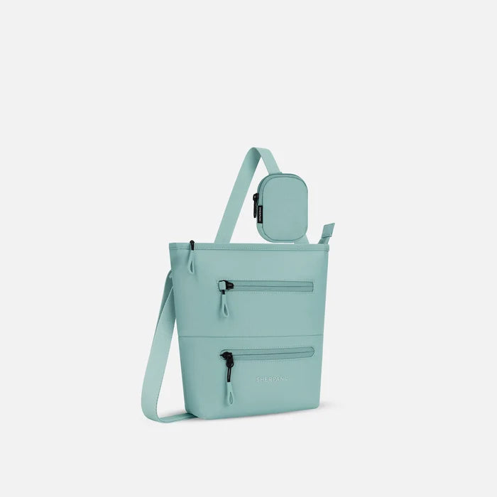 A Sherpani Surf Blue Crossbody Bag, 3/4 view showing front lockable zipper pockets and the pouch attached to the strap. #color_surf-blue