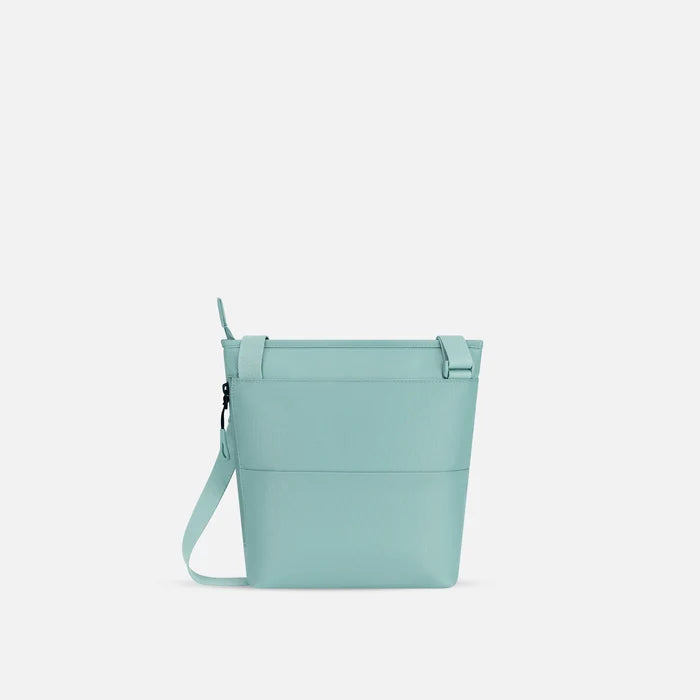A Sherpani Sadie Surf Blue Crossbody Bag, back view showing the side pocket.  #color_surf-blue
