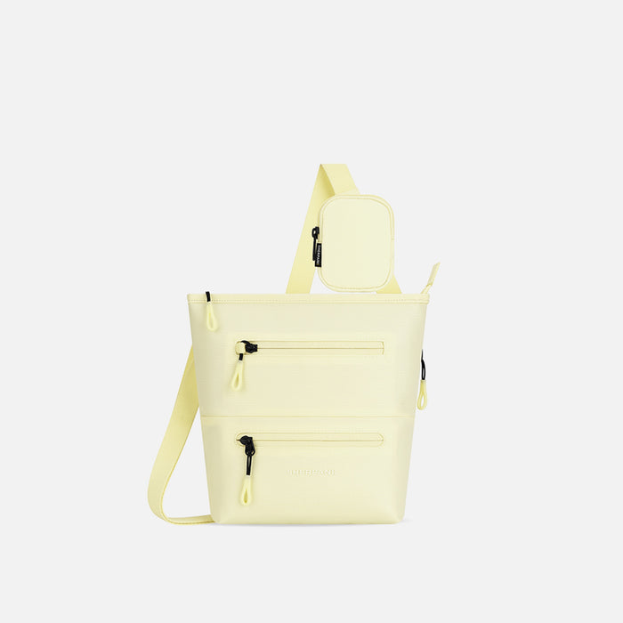 A Sherpani Sadie Sol Yellow Crossbody Bag, front view showing lockable Pocket & strap pouch against white backdrop. #color_sol-yellow