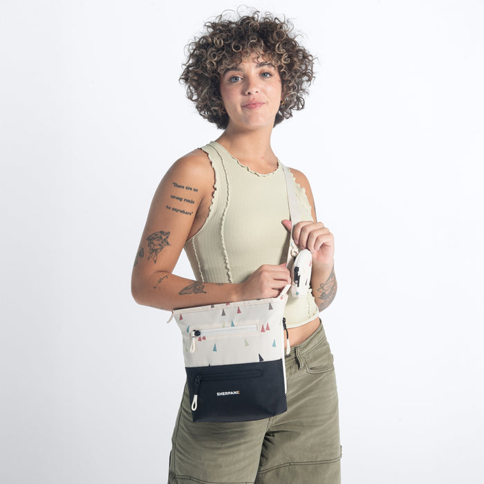 Woman wearing a Sherpani Sadie Terrazzo Print Crossbody Bag against white backdrop. #color_terrazzo-print