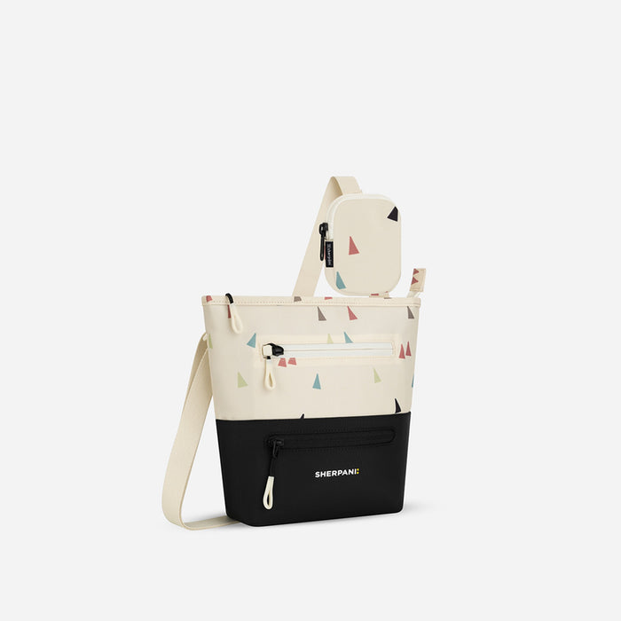 A Sherpani Sadie Terrazzo Print Crossbody Bag, 3/4 view showing lockable Pocket and strap pouch against white backdrop.   #color_terrazzo-print