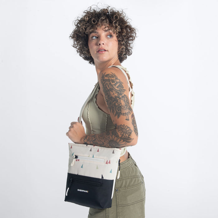 Woman wearing a Sherpani Sadie Terrazzo Print Crossbody Bag on her shoulder against white backdrop. #color_terrazzo-print