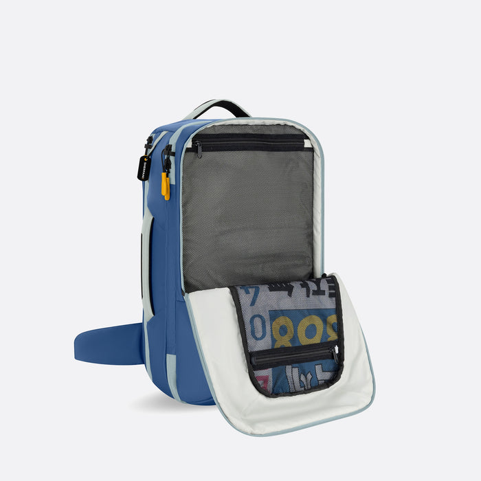 A Sherpani Santiago Seastone Travel Backpack, 3/4 view showing inside pockets on white backdrop. #color_seastone