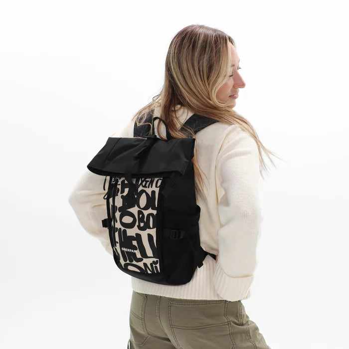 Woman wearing a Sherpani Sedona Ciao Print Backpack on her back against white background. #color_ciao-print