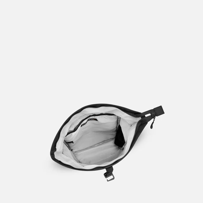 A Sherpani Sedona Raven Black Backpack, above view showing inside the main compartment on white backdrop.  #color_raven-black