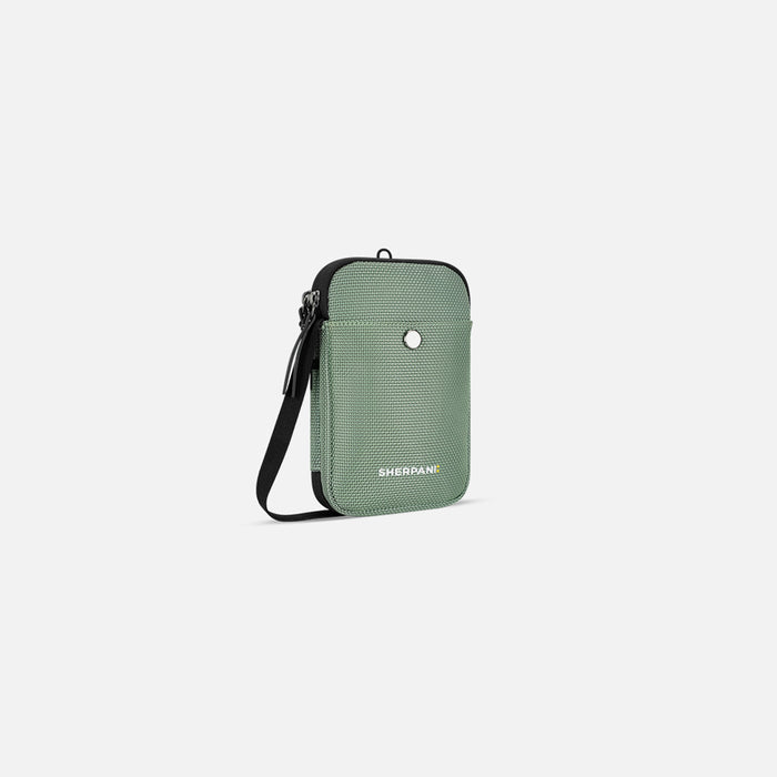A Sherpani Simplicity Aloe Mist Green Anti-Theft Crossbody Wallet, 3/4 view showing pocket and strap on a white background. #color_aloe-mist-green