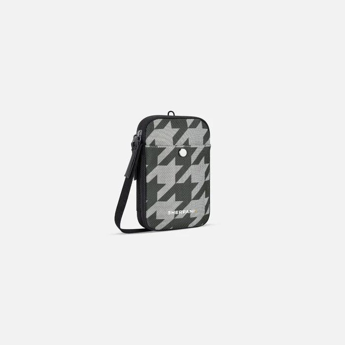 A Sherpani Simplicity Houndstooth Anti-Theft Crossbody Wallet, 3/4 view showing main pocket and strap on a white background. #color_houndstooth-print