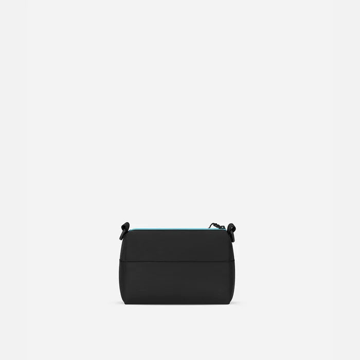 A Sherpani Skye Chromatic Black Shoulder Bag, back view on a white backdrop.  #color_chromatic-black