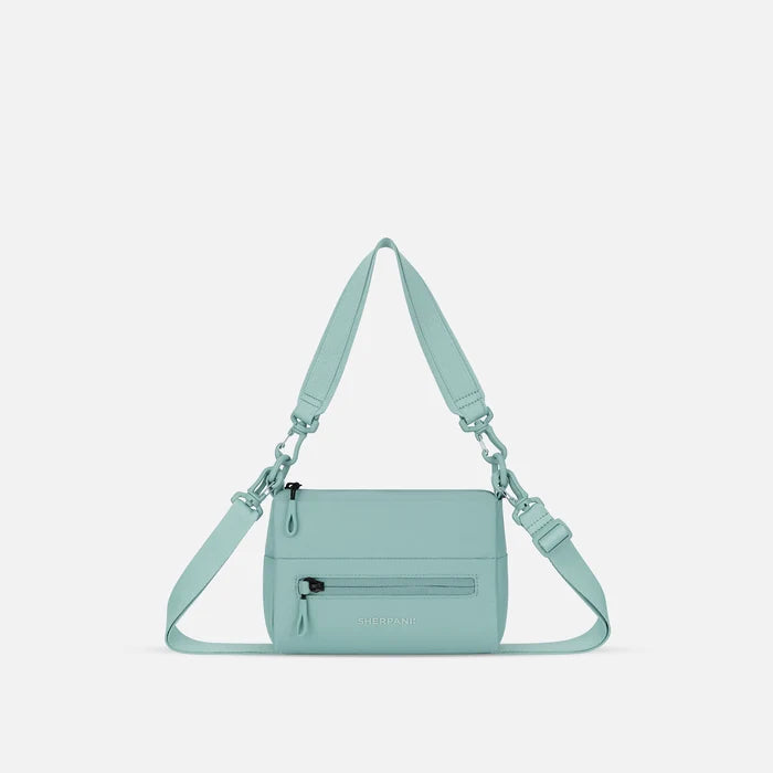 A Sherpani Surf Blue Shoulder Bag, front view showing lockable pocket and strap options on white backdrop.  #color_surf-blue