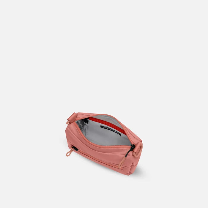 A Sherpani Skye Desert Pink Shoulder Bag, above view showing inside pockets on a white backdrop. #color_desert-pink