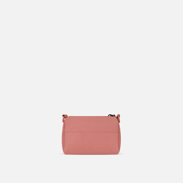 A Sherpani Skye Desert Pink Shoulder Bag, back view on a white backdrop.  #color_desert-pink