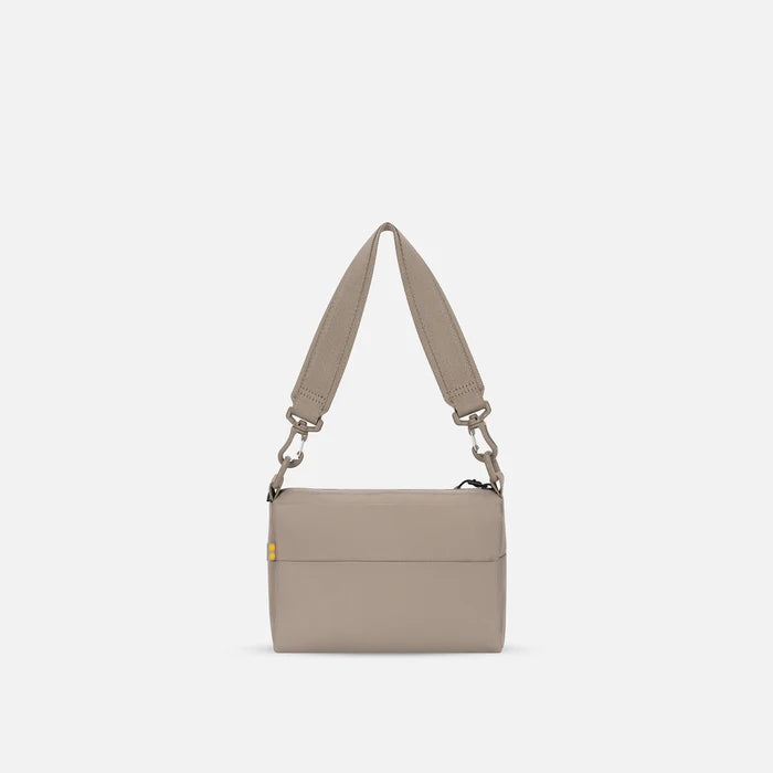 A Sherpani Skye Dune Shoulder Bag, back view on a white backdrop.  #color_dune-tan