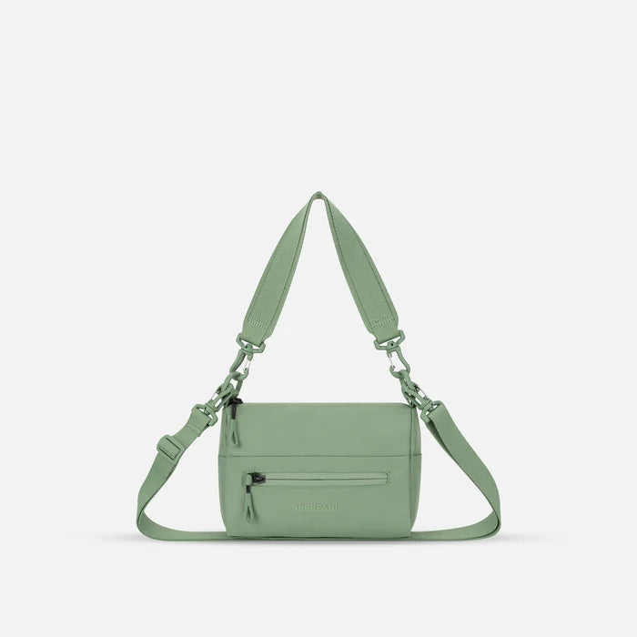 A Sherpani Olivine Shoulder Bag, front view showing lockable pocket and strap options on white backdrop.  #color_olivine-green