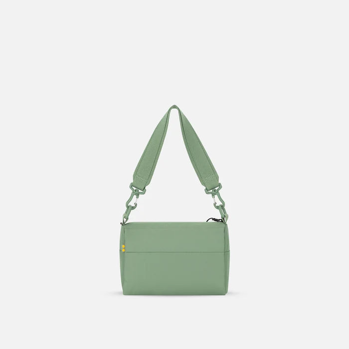 A Sherpani Skye Olivine Shoulder Bag, back view on a white backdrop.  #color_olivine-green