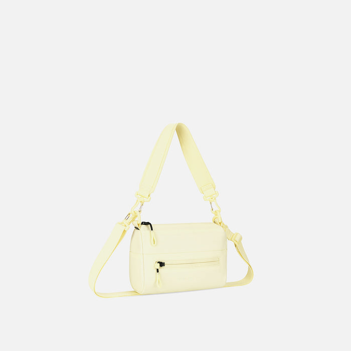 A Sherpani Sol Yellow Shoulder Bag, 3/4 view showing lockable pocket and strap options on white backdrop. #color_sol-yellow