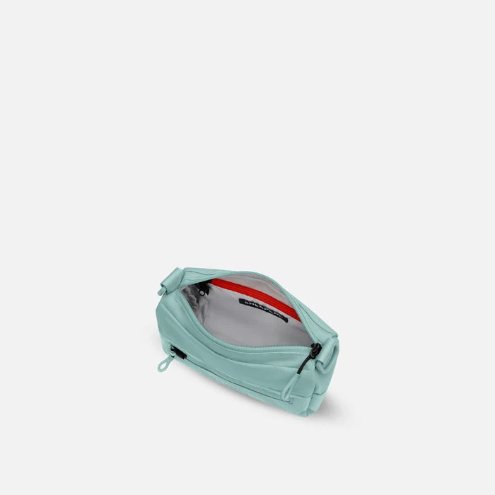 A Sherpani Skye Surf Blue Shoulder Bag, above view showing inside pockets on a white backdrop. #color_surf-blue